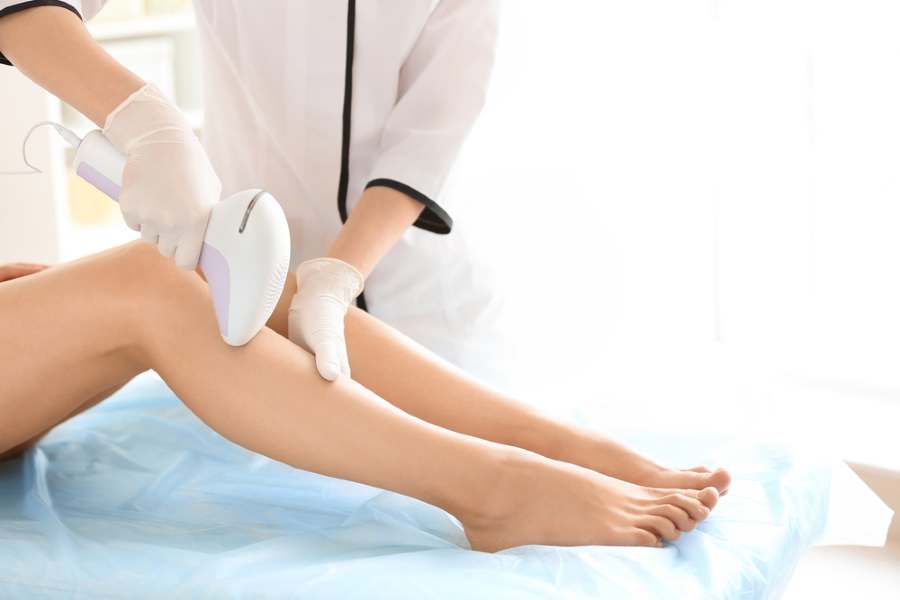 jambes de femme et épilateur à lumière pulsée