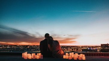 Couple enlacé regardant un coucher de soleil