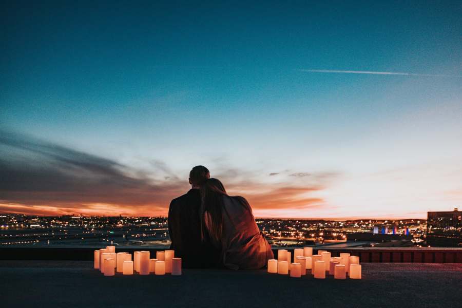 Couple enlacé regardant un coucher de soleil