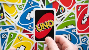 man hand holding uno game card showing the reverse of the card w
