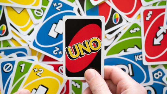 man hand holding uno game card showing the reverse of the card w