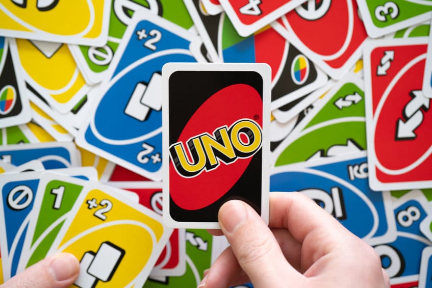 man hand holding uno game card showing the reverse of the card w