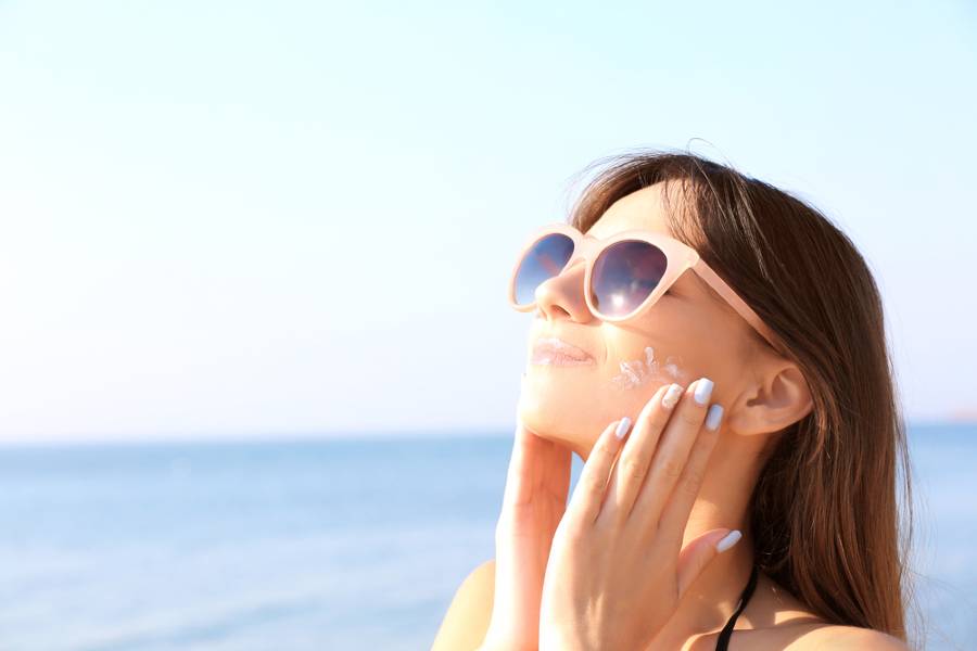femme appliquant de la crème solaire bio