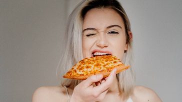 femme qui mange une part de pizzza