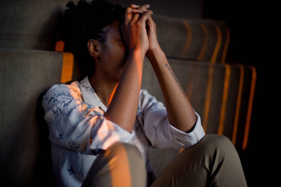 femme se tenant la tête entre ses mains