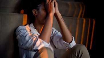 femme se tenant la tête entre ses mains