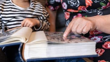 petite fille regardant album photo avec grands parents
