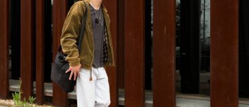 jeune homme marchant devant un mur en acier corten